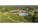 Aerial view of the community clubhouse, pool, golf course, and well-manicured landscaping at 6174 Spinnaker Loop, Lady Lake, FL 32159