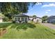 Well-manicured lawn and landscaping accent this one-story home with stylish shutters and grey roof at 6174 Spinnaker Loop, Lady Lake, FL 32159