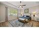 Relaxing main bedroom featuring a tray ceiling, fan, and a comfy bed at 6174 Spinnaker Loop, Lady Lake, FL 32159