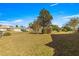 Large grassy backyard with mature trees and a view of neighboring houses at 7451 Sw 111Th Pl, Ocala, FL 34476