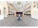 Expansive ballroom with chandeliers, stage, and ornate carpet at 7451 Sw 111Th Pl, Ocala, FL 34476