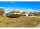 Yellow single-story home with a brick-paved driveway, manicured front yard with green bushes and a red tile roof at 7451 Sw 111Th Pl, Ocala, FL 34476