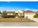 Charming yellow single-story home with red tile roof, a manicured lawn, and an attached two-car garage at 7451 Sw 111Th Pl, Ocala, FL 34476