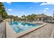 A pool with swimming lanes and a jacuzzi, plus tables, chairs, lounge chairs and a clubhouse in the background at 7451 Sw 111Th Pl, Ocala, FL 34476