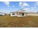 Backyard view showing the covered patio and freshly cut grass of this single-Gathering home at 7821 Sw 55Th Ln, Ocala, FL 34474