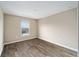 Bright bedroom with wood-style flooring, neutral walls, and a window overlooking the neighborhood at 7821 Sw 55Th Ln, Ocala, FL 34474