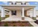 Inviting front porch featuring white columns with stone accents and a well-maintained yard at 7821 Sw 55Th Ln, Ocala, FL 34474