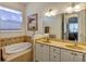 Well-lit bathroom with dual sinks, a soaking tub, tile backsplash, and a large mirror at 8751 Sw 57Th Court Rd, Ocala, FL 34476