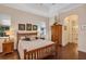 Bright bedroom with neutral walls, hardwood floors, and a comfortable wood-framed bed near an ensuite bathroom at 8751 Sw 57Th Court Rd, Ocala, FL 34476