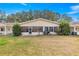 Backyard view of the house with a screened in patio, small bushes and a green lawn at 8891 Sw 96Th Ln # E, Ocala, FL 34481