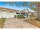 Front exterior view of the house with garage, covered porch and lawn with leaves at 8891 Sw 96Th Ln # E, Ocala, FL 34481