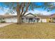 Exterior of home featuring garage, covered porch, manicured lawn and mature trees at 8891 Sw 96Th Ln # E, Ocala, FL 34481