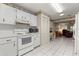 Bright kitchen features white appliances, cabinetry, and tile flooring throughout the space at 8891 Sw 96Th Ln # E, Ocala, FL 34481