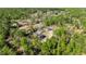 An aerial view shows a house nestled among the trees, surrounded by lush greenery, in a secluded area at 8981 Sw Sw 209Th Cir, Dunnellon, FL 34431