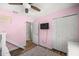 Bright bedroom features ceiling fan, wood floors, closet, and pink walls at 8981 Sw Sw 209Th Cir, Dunnellon, FL 34431