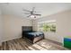 Bright bedroom with hardwood floors, a window overlooking the backyard, and a ceiling fan at 8981 Sw Sw 209Th Cir, Dunnellon, FL 34431