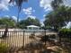 Community pool surrounded by black metal fencing and lush, green trees at 8981 Sw Sw 209Th Cir, Dunnellon, FL 34431