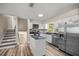 Bright kitchen featuring wood-look floors, white cabinets and stainless steel appliances at 8981 Sw Sw 209Th Cir, Dunnellon, FL 34431