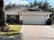 Inviting single-story home with brick accents and a spacious two-car garage, complemented by a neat, paved driveway at 9133 Sw 91St Cir, Ocala, FL 34481