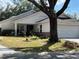 Attractive single-story home with a well-maintained lawn and a two-car garage, framed by mature trees at 9133 Sw 91St Cir, Ocala, FL 34481