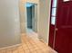 Tiled hallway with a red front door and access to the laundry area at 9133 Sw 91St Cir, Ocala, FL 34481