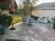 Brick patio with comfortable outdoor seating and an umbrella for shade, perfect for entertaining at 9133 Sw 91St Cir, Ocala, FL 34481