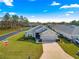 An aerial view showcases the gray house with a two car garage, and a well maintained yard at 1 Diamond Cove Pl, Ocala, FL 34472