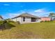 Backyard view of the home showcasing the screened lanai and grassy lawn at 1 Diamond Cove Pl, Ocala, FL 34472