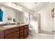 Bathroom featuring double sinks, granite counters, and a glass-enclosed shower at 1 Diamond Cove Pl, Ocala, FL 34472