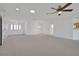 A spacious living room with a ceiling fan, bright lighting, and open access to other rooms at 10003 Sw 90Th Loop, Ocala, FL 34481