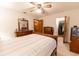 Bright bedroom featuring a ceiling fan, a dresser with a decorative mirror, and a walk-in closet at 10498 Sw 99Th Ave, Ocala, FL 34481