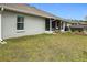 A home's backyard featuring a cozy screened-in patio, a well-kept lawn, and a rejuvenating hot tub for outdoor relaxation at 1083 Se 65Th Cir, Ocala, FL 34472