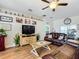 Comfortable living room with hardwood floors, a ceiling fan, and a large TV at 1083 Se 65Th Cir, Ocala, FL 34472