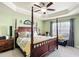 Spacious main bedroom featuring a four-poster bed, tray ceiling, and ample natural light at 1083 Se 65Th Cir, Ocala, FL 34472