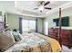 Spacious main bedroom featuring a four-poster bed, tray ceiling, and a sitting area near the window at 1083 Se 65Th Cir, Ocala, FL 34472