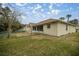 A fenced backyard with a view of the home's exterior and a screened-in porch, perfect for outdoor relaxation at 10884 Sw 53Rd Cir, Ocala, FL 34476