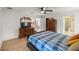 Comfortable bedroom featuring a plaid bedspread, ceiling fan, and light wood flooring at 10884 Sw 53Rd Cir, Ocala, FL 34476