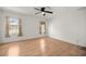 Bright bedroom features wood-look floors, a ceiling fan and two windows for natural light at 10884 Sw 53Rd Cir, Ocala, FL 34476