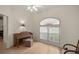 Bedroom with hardwood floors, vaulted ceilings, large window, piano, and accent chairs at 10884 Sw 53Rd Cir, Ocala, FL 34476