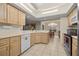 Bright kitchen features white appliances, light wood cabinetry, and a view into the adjacent dining area at 10884 Sw 53Rd Cir, Ocala, FL 34476