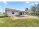 Back of house featuring screen porch, small yard, white siding, and blue skies at 11862 Se 72Nd Terrace Rd, Belleview, FL 34420