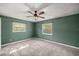 The cozy carpeted bedroom features two windows that let in natural light and a ceiling fan at 11862 Se 72Nd Terrace Rd, Belleview, FL 34420