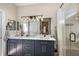 Bathroom with double sink vanity, modern lighting fixtures, and a glass-enclosed shower at 13096 Se 93Rd Terrace Road, Summerfield, FL 34491