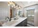 Bathroom featuring double sinks, a glass enclosed shower, and modern lighting fixtures at 13096 Se 93Rd Terrace Road, Summerfield, FL 34491