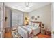 Neutral bedroom with hardwood floors, a ceiling fan, and decoratively arranged baskets on the wall at 13096 Se 93Rd Terrace Road, Summerfield, FL 34491