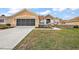 Attractive home featuring stone accents, manicured lawn, and a spacious driveway leading to a two-car garage at 13096 Se 93Rd Terrace Road, Summerfield, FL 34491