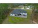 Back aerial view of the home with a covered patio and a well-manicured lawn at 13105 Sw 73Rd Avenue Rd, Ocala, FL 34473