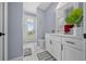 Well-lit bathroom with a large vanity, white cabinets, stylish decor, and a door to the outside at 13105 Sw 73Rd Avenue Rd, Ocala, FL 34473