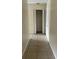 Hallway with tile floors leading to closet with bi-fold doors and shelf storage at 15 Clear Way, Ocala, FL 34472