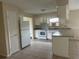 Well-lit kitchen with white cabinets and appliances, and a breakfast bar overlooking the living area at 15 Clear Way, Ocala, FL 34472